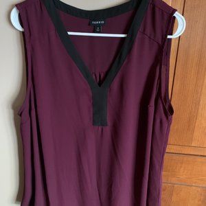 elegant, sleeveless,  silky,  plum-colored blouse with black trim